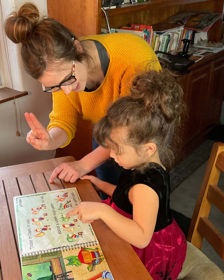 Mom and daughter are reading Dr. Joseph's Fingerspelling Book